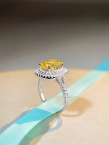 Detail of a luxury S925 silver ring with a large yellow cushion-cut halo gemstone