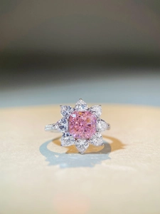 Macro detail of a S925 silver ring featuring a cushion-cut pink stone in a flower halo