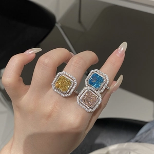 Gros plan de bagues halo jaune, bleu et champagne avec pierres de taille Radiant