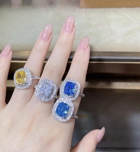 Macro detail of cushion-cut rings with double halo in yellow, white, and blue tones