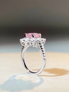 Macro detail of a pink oval gemstone ring with marquise diamond floral cluster setting
