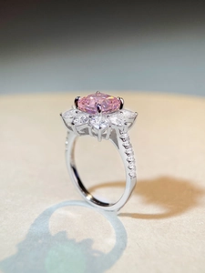 Macro shot of cushion cut pink gemstone ring with halo sunflower design and pavé band