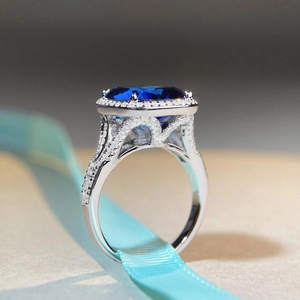 Bague luxueuse en argent 925 avec un grand saphir bleu ovale et entourage de diamants