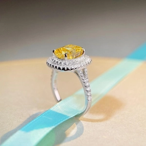 Luxurious cushion-cut yellow gemstone ring with halo diamonds on a silver band