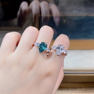 Detail of S925 silver rings featuring pear-cut emerald and clear zircon stones