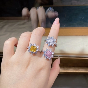 Detailed view of three sunflower-shaped silver rings with yellow, pink and white stones
