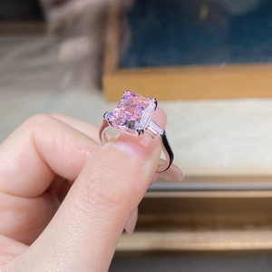 Detail of pink radiant cut gemstone ring with trapezoidal side diamonds in silver