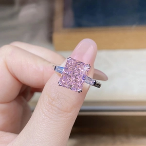 Macro detail of radiant cut pink stone ring with side trapezoid diamonds on silver band