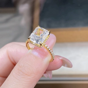 Macro shot of 18K gold plated S925 silver ring featuring a radiant cut centerpiece stone