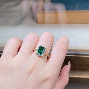 Close-up of 18K gold plated silver emerald cut ring worn on finger with micro-pave stones