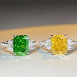 Detail of S925 silver rings with yellow and green radiant cut stones in three-stone setting