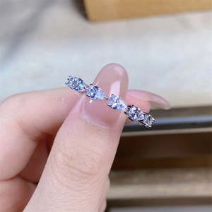 Detail of five pear-cut sparkling teardrop stones on a polished silver ring band