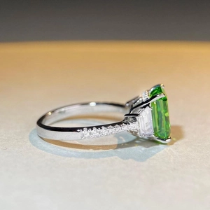 Vue macro d'une bague en émeraude verte avec pierres latérales taillées en baguette