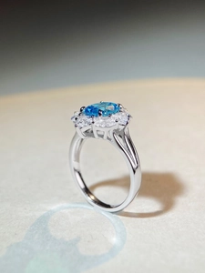 Detail view of oval aquamarine silver ring with radiant petal-shaped zircon cluster setting