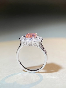 Side macro view of oval pink sapphire ring with marquise cluster setting and claw detail