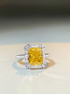 Macro shot of rectangular yellow zircon ring with intricate halo and pave diamonds