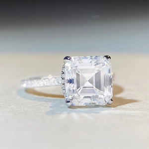 Macro detail of Asscher cut moissanite ring with S925 silver pave setting on stone base