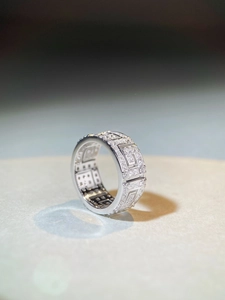 Macro shot of silver ring featuring wide geometric pattern and pave set zircons