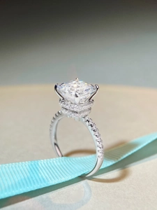 Macro shot of S925 silver moissanite ring with radiant cut halo and diamond side stones