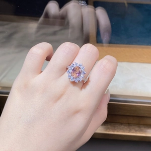 Macro view of flower-shaped silver ring with pink sapphire and micro-pave diamonds
