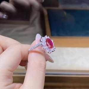 Close-up of luxury floral ring with oval red gemstone and sparkling white crystals