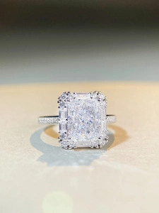 Macro detail of radiant ice cut silver ring with halo setting and pavé side stones