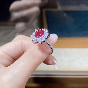 Detailed close-up of a vintage halo ruby ring with sunflower-shaped diamond settings