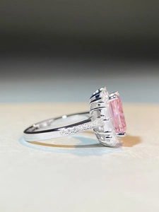 Close-up of pink emerald-cut zircon ring in silver finish with pavé diamond setting