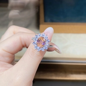 Macro view of flower-shaped silver ring with champagne gemstone and white zircon petals