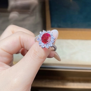 Close-up of S925 silver ring with pigeon blood red stone and sunflower petal diamond halo
