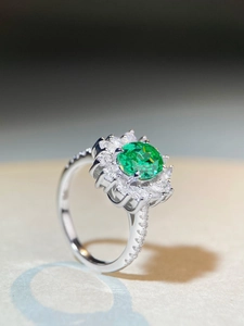 Macro shot of S925 silver ring featuring an oval green gemstone with surrounding diamonds