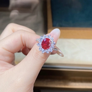 Close-up of S925 silver ring featuring a large ruby center and floral diamond clusters