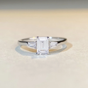 Macro shot of emerald cut moissanite ring with side stones in sterling silver setting