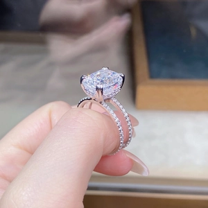 Macro shot of cushion-cut solitaire ring with double-row pavé band in silver