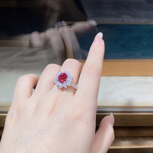 Macro shot of oval ruby ring with halo diamonds on S925 sterling silver band