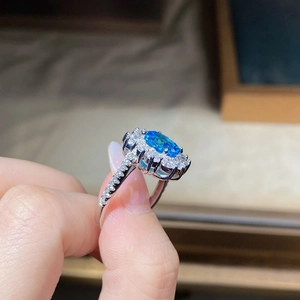 Macro shot of oval aquamarine silver ring with double halo diamond setting details