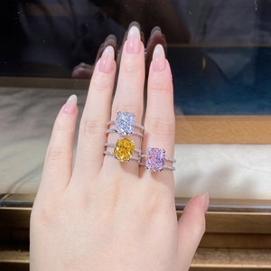 Detailed view of radiant cut colorful zircon rings on fingers with double row pavé setting