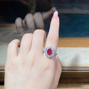 Close-up of S925 silver sunflower ring with ruby red zircon on a woman's finger