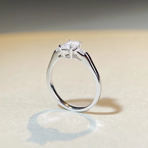 Emerald cut moissanite ring in sterling silver casting a heart-shaped shadow