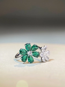 Macro shot of S925 silver ring featuring green pear-cut stones in a flower design