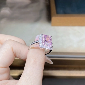 Macro shot of rectangular pink zircon ring with pavé diamond band in silver