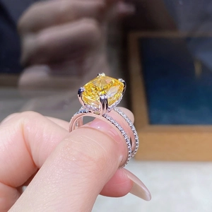 Macro detail of cushion-cut yellow gemstone ring with pavé-set double band in silver