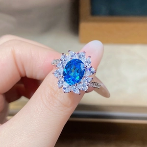 Close-up of S925 silver ring with sunflower-shaped blue zircon being worn on a hand