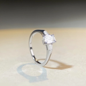 Three-stone emerald cut moissanite ring with baguette side stones in sterling silver