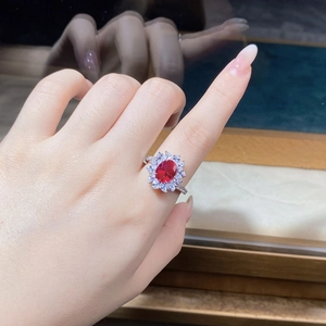 Detail of sunflower-shaped ruby ring with marquise-cut zircons on a silver band
