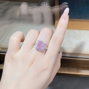 Macro shot of a pink emerald-cut zircon ring in 925 silver setting with diamond pave