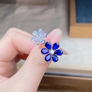 Macro view of 925 silver flower ring featuring blue and clear pear-cut zircon stones