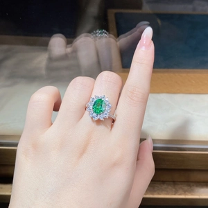 Close-up of S925 silver ring featuring an oval green gemstone with sunflower halo design
