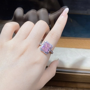 Close-up of radiant cut pink zircon ring with pave diamond halo on a model hand