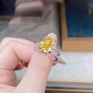 Detailed close-up of a large yellow cushion cut zircon ring with a double-row pavé band
